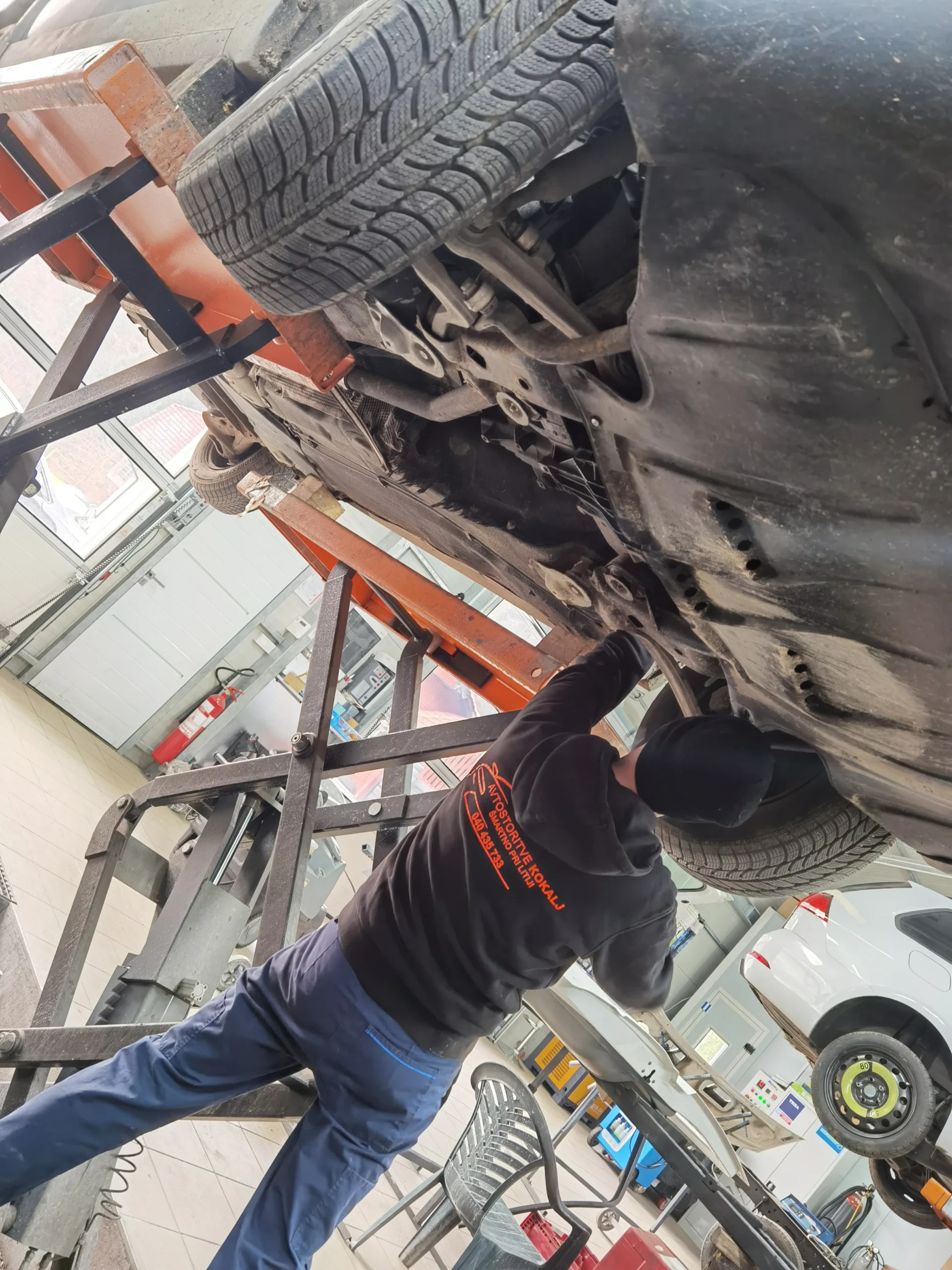 Avtomehanik pod vozilom.
